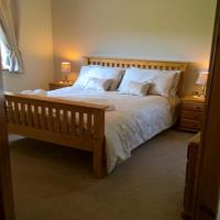 Master bedroom with kingsize bed and dual aspect windows.